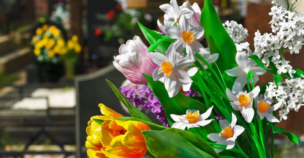 Bouquet de fleurs de printemps avec jonquilles blanches, tulipes jaunes et lilas dans un cimetière